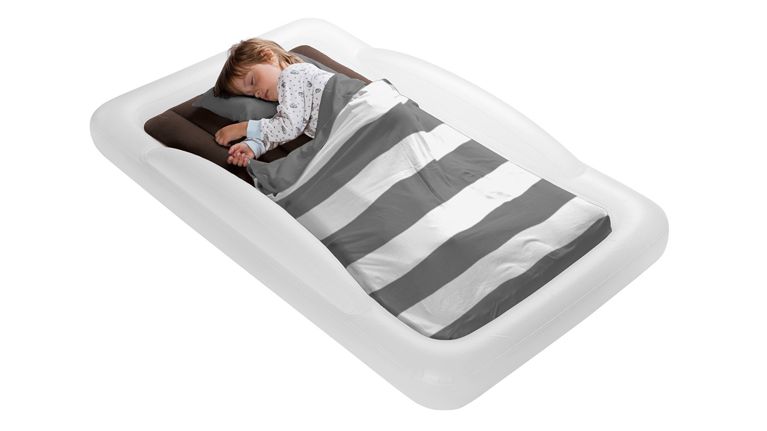 A little boy sleeping on an inflatable grey and white bed