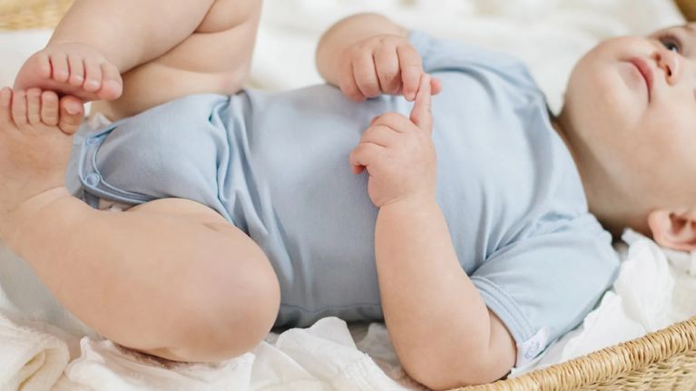 A baby wearing a gender-neutral onesie from Luna Cay