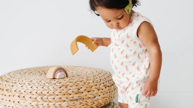 A child modeling a gender-neutral playsuit from Parade Organics