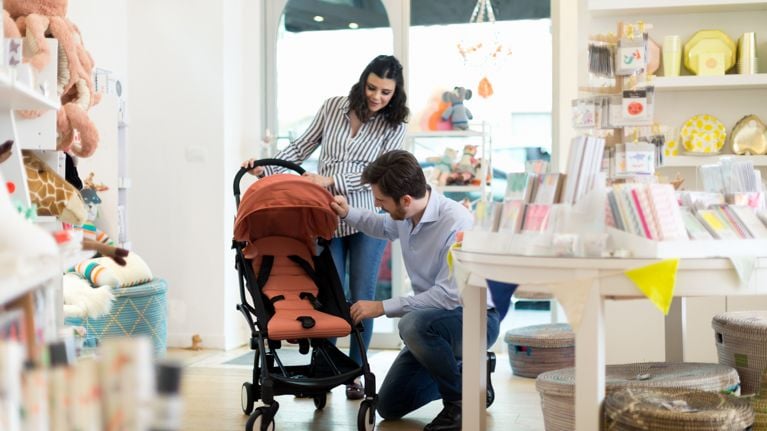 Husband and pregnant wife shopping for pram