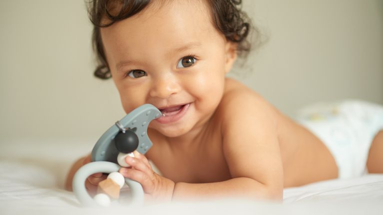 Shot of an adorable baby girl playing with a teething rattle at home