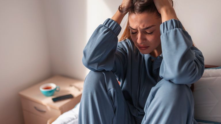 Anxious woman crying in bed