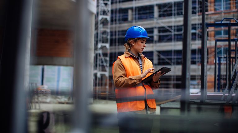 woman with hard hat holding a tablet