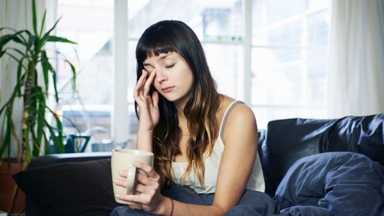 woman looking tired sitting on sofa