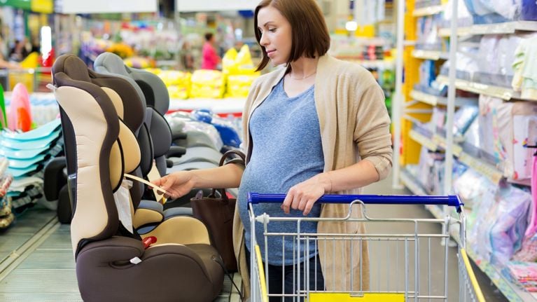 pregnant woman in shop buy car baby seat