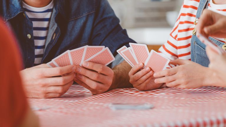 Family playing cards on a red checked table cloth