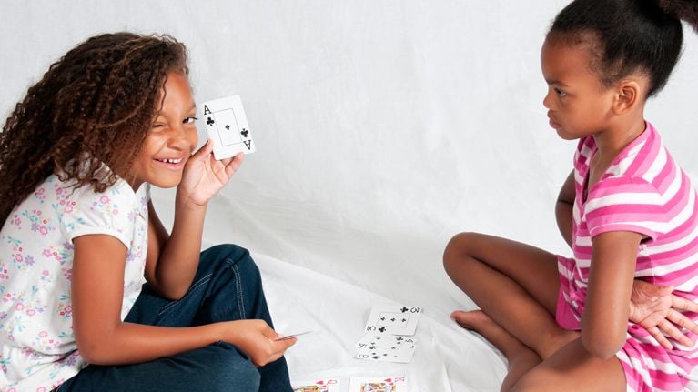 Two girls play a card game
