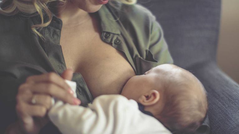 A blonde woman breastfeeding her baby