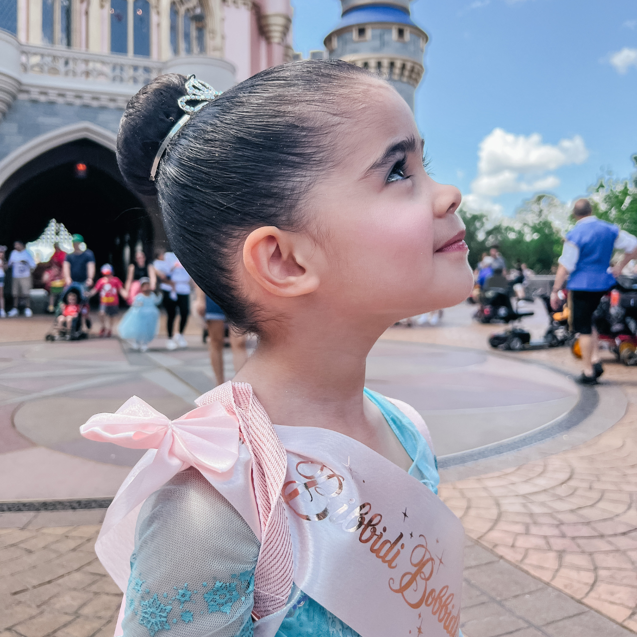 author megan's daughter standing in front of the castle after going to the bibbidi bobbidi boutique