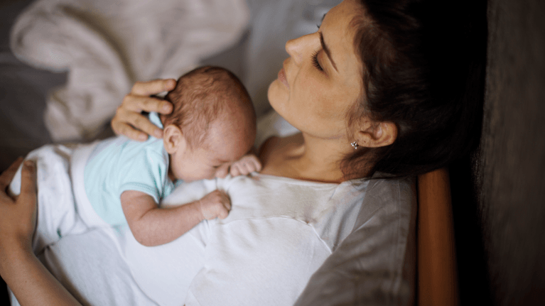 new mom laying in bed with new baby