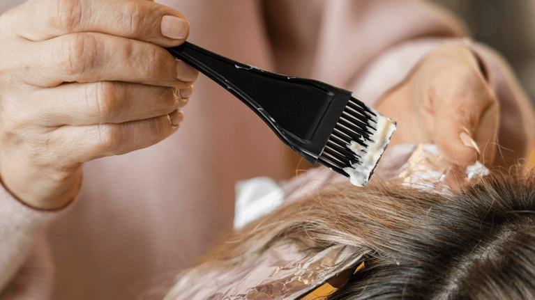 close up shot of a woman's head while getting her hair dyed