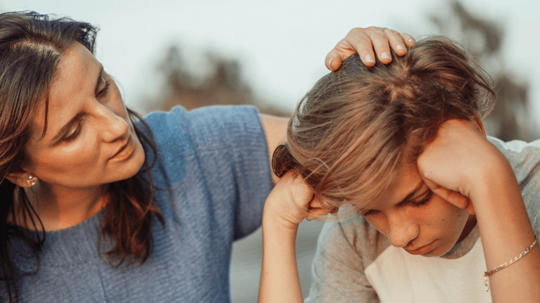 mom sitting with son who looks concerned