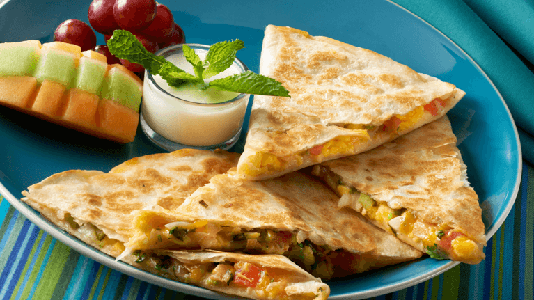 plate of quesadillas with a side of fruit