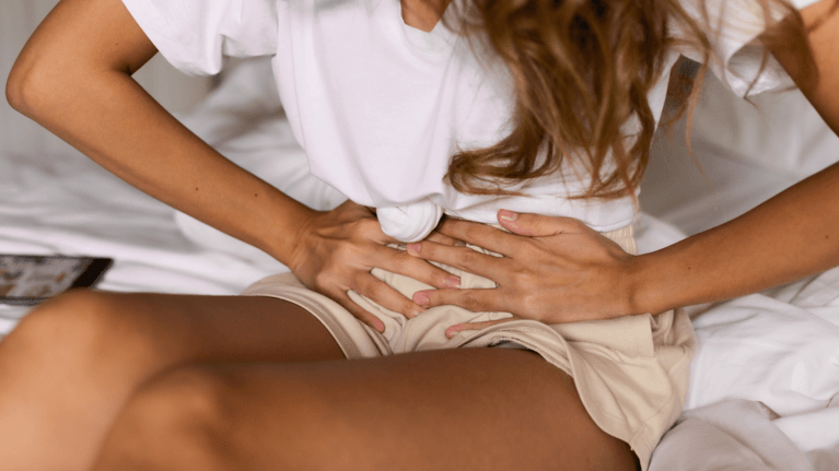 woman holding her stomach in pain