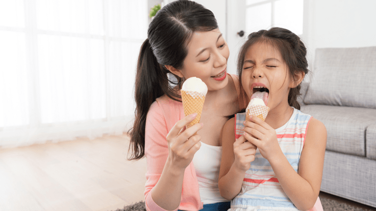mom and little girl eating ice cream and being silly